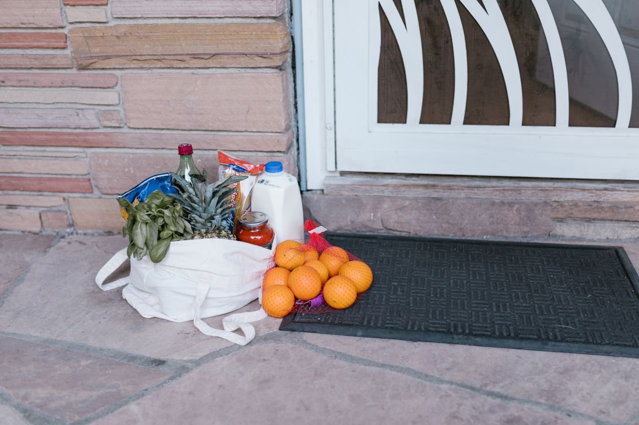 The Art of Drawing Readers In: Your attractive post title goes here Reusable bag with groceries and fruits left at doorstep, highlighting delivery service.